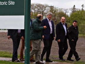 Prime Minister Stephen Harper, 2nd from left, visits Grosse-Ile, Que., Friday May 22, 2015. The federal government says it will invest $30 million over three years in the country's tourism sector in order to attract more Americans north of the border. THE CANADIAN PRESS/Clement Allard