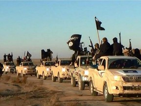 In this undated photo released by a militant website, which has been verified and is consistent with other AP reporting, militants of the Islamic State group hold up their weapons and wave its flags on their vehicles in a convoy on a road leading to Iraq, while riding in Raqqa city in Syria. The Islamic State group is notorious for the atrocities it committed as it overran much of Syria and neighboring Iraq. But to its supporters, it is engaged in an ambitious project: building a new nation ruled by what radicals see as "God's law," made up of Muslims from around the world whose old nationalities have been erased to unite in the "caliphate."