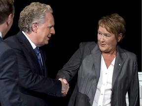 Quebec Premier Jean Charest shakes hands with PQ leader Pauline Marois on the set prior to the leaders debate Sunday, August 19, 2012 in Montreal.