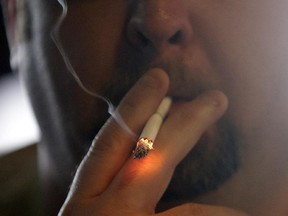 Josh Lott smokes a cigarette inside Kajun's Pub, Tuesday, April 21, 2015, in New Orleans. Starting at midnight Tuesday, smoking will no longer be permitted in bars, gambling halls and many other public places such as hotels, workplaces, private clubs and stores.