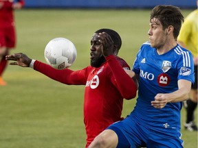 Toronto FC Jozy Altidore, left, battles for the ball against Montreal Impact Maxim Tissot, right, during first half semi-final Canadian Championship soccer action in Toronto on Wednesday, May 13, 2015.