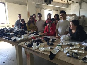 Lee-Ann Sacks (third from left) with her Laval Junior High School students at Reliable Hosiery. Owner Herman Gruenwald is donating the socks to homeless shelters, and the students were sorting and matching them as part of a community service project.
