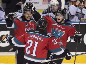 Kelowna Rockets Madison Bowey, left, is congratulated by teammates Devante Stephens, centre, and Dillon Dube after he scored the second goal during first period action Monday, May 25, 2015 at the Memorial Cup tournament in Quebec City.