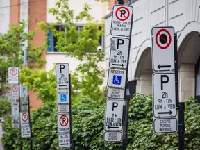 Parking restriction signs and signs for vignette and handicap permits on the corner of de Gaspé and Laurier streets in the neighbourhood of Plateau-Mont-Royal in Montreal on Tuesday, August 13, 2013.