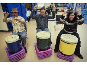 Syed Asmat Ali, left, Stuart Nagus, and Gloria Sexsmith add arm movements to their drumming during Broadway class designed for people with Parkinson's disease at the Cummings Centre in Montreal.