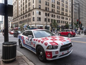 A police cars plastered with stickers at the corner of Peel Street at de Maisonneuve Blvd in Montreal, on Thursday, July 31, 2014.