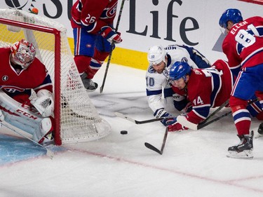 Montreal Canadiens defenceman Alexei Emelin and Tampa Bay Lightning left wing Brenden Morrow struggle for the loose puck as Montreal Canadiens goalie Carey Price, left, and Montreal Canadiens centrre Lars Eller look on during NHL semifinal action at the Bell Centre in Montreal on Friday May 1, 2015.