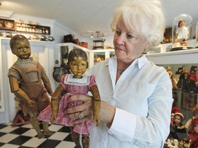 Madeleine Léger with a couple of wooden dolls with articulating limbs from the 1750s made in eastern Europe, at her home in Hudson.  Her collection of over 250 dolls, which she calls a museum, can be seen on an appointment basis.