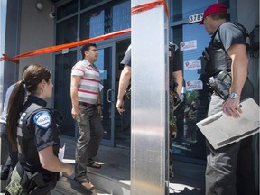 Mehmet Kocabas, second from left, talks to Montreal police in front of the Montreal Turkish Community Centre in Montreal, on Sunday, May 17, 2015. The centre was vandalized early Sunday morning for the second time this year.