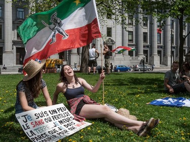 A small gathering, including Elisabeth De Lagrave, left, and Marie-Andrée Daigneault amassed near the Wilfred Laurier statue in Dorchester Square in Montreal, on Monday, May 18, 2015 as part of the Fete des patriotes organized by the Saint-Jean-Baptiste Society.