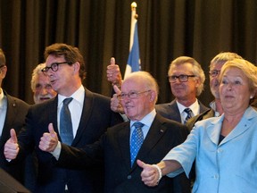 Pierre Karl Péladeau, left, and former Quebec premiers Bernard Landry and Pauline Marois give the crowd a thumbs up at a gala dinner in Montreal on Monday, May 18, 2015.