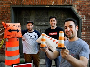 Main and Local co-owners, from left,  Andrew Cohen, David Prince and Jonny Goldmaker display their company's goods: Cohen stands next to a construction detour pillow, sporting a Montreal Royals tribute shirt; Prince, in a Poutine T-shirt, with an STM bus transfer pillow; Goldmaker, in a dépanneur T-shirt, holds  a salt and pepper shaker set in the shape of construction cones.