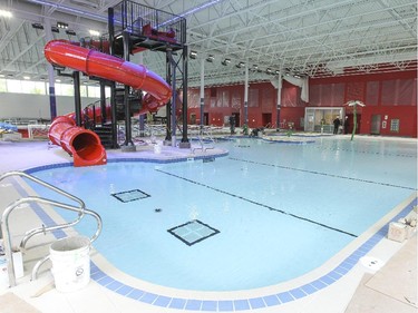 Another view of the recreational pool with a water slide, a fountain, seats with water jets and a walk-in entrance.