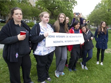 Nurses from a neonatal intensive care unit at the Montreal Children's Hospital watch as ambulances leave with patients during the move to the hospital's new site at the MUHC Glen Campus, Sunday May 24, 2015