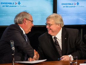 Louis Godin, president of the Fédération des médecins omnipraticiens du Québec, left, shakes hands with Quebec Health Minister Gaétan Barrette after announcing that the province's family physicians and the Quebec government reached an agreement to avert a proposed quota system for family physicians as would be imposed by Bill 20, in Montreal on Monday, May 25, 2015.