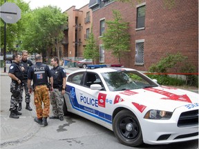 Montreal police officers at the scene of a homicide at an apartment building on Robillard Street near St. Andre in Montreal, Thursday May 28, 2015.  Police were called to an apartment in the building on Wednesday evening where they found a man stabbed.  He was taken to hospital where he died later.  It's the city's 10th homicide of the year.  (Phil Carpenter   / MONTREAL GAZETTE)