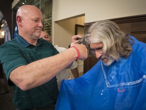 Fred Fox, left, brother of Terry Fox, cuts the hair of Les Hay at the Windmill Heights Golf Club on Thursday, May 28, 2015.