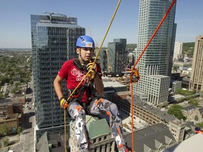 Former Make-A-Wish child Jonathan Emond rapells down the side of the Place du Canada building, Friday May 29, 2015, as part of a fundraising rappelling event to raise money for the Make-A-Wish Foundation. It was the group's second annual rappelling event and they hoped to raise $70,000.