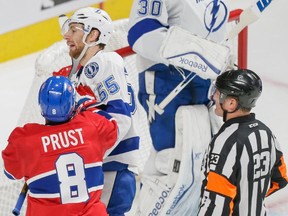 Montreal Canadiens right wing Brandon Prust, bottom left, pushes Tampa Bay Lightning defenceman Braydon Coburn, top left, as referee Brad Watson, right, looks on during the first period of game two of their NHL eastern conference semi-final hockey series at the Bell Centre in Montreal on Sunday, May 3, 2015. Prust apologized on Tuesday, May 5 for comments he made against Watson.