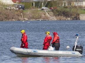 Police and other searchers comb the shores of the Chambly Canal, May 5, 2015, for a teen who disappeared Monday night after his boat capsized.