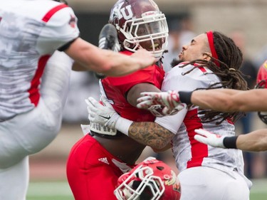 McGill's Luis Guimont-Mota (right) of Team East  has his helmet knocked off by Wayne Moore, who he was blocking during a punt, at the CIS East-West Bowl at Percival Molson stadium in Montreal Saturday, May 9, 2015. Top university players in country took part in the game which was won by the team from the east.