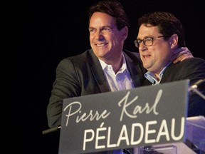 Pierre Karl Péladeau, left, hugs Bernard Drainville after Drainville gave a speech supporting Pierre Karl Péladeau for the leadership of the party at a leadership rally in Montreal on Saturday May 9, 2015.