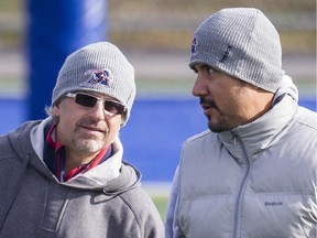 Injured Montreal Alouettes quarterback Anthony Calvillo, right, and Alouettes head coach Jim Popp, left, walk through the field during a team practice in Montreal on Wednesday, Nov. 6, 2013.