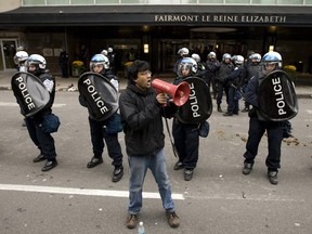 Social justice activist Jaggi Singh uses a bullhorn to address protesters gathered outside the Queen Elizabeth Hotel in Montreal during speech by former United States president George W. Bush in Montreal Thursday, October 22, 2009.