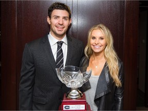 Canadiens goalie Carey Price poses for a photograph with his wife, Angela Webber, in front of Price's Jean Béliveau Trophy at the Bell Centre on Oct. 4, 2014. The Jean Béliveau Trophy is awarded to a player for his involvement with charities and in the community.