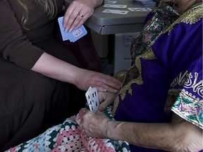 A palliative care nurse plays cards with a patient at the West Island Palliative Care Centre in 2007.