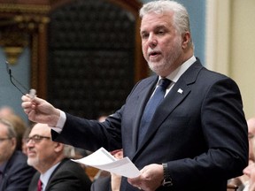 Quebec Premier Philippe Couillard responds to the Opposition during question period Monday, April 20, 2015 at the legislature in Quebec City. Quebec Finance Minister Carlos Leitao, left, looks on. The government invoked exception to pass a special legislation on the budget.