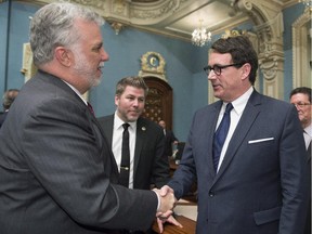 Premier Philippe Couillard, left, greets Quebec Opposition leader Pierre Karl Péladeau as he enters the legislature for question period Tuesday, May 19, 2015, in Quebec City.
