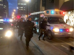 Police officers exit buses as people take part in the the annual anti-capitalist May Day protest in Montreal on Friday May 1, 2015.