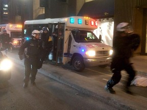 Police officers exit buses as people take part in the the annual anti-capitalist May Day protest in Montreal on Friday May 1, 2015.