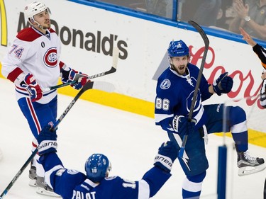Tampa Bay Lightning right wing Nikita Kucherov, right, celebrates his goal with teammate Tampa Bay Lightning left wing Ondrej Palat, bottom, as Montreal Canadiens defenseman Alexei Emelin reacts during the first period of Game 6 of their NHL Eastern Conference semifinal series at Amalie Arena in Tampa, Fla., on Tuesday, May 12, 2015.
