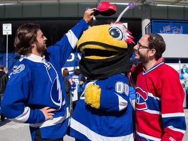 A Tampa Bay Lightning fan removes the hat of Montreal Canadiens fan Benjamin Nadler, right, after he tried to place it on the Bolts mascot ThunderBug, centre, outside the Amalie Arena before the start of game three of NHL eastern conference semi-final hockey series between the Montreal Canadiens and the Tampa Bay Lightning in Tampa on Wednesday, May 6, 2015.