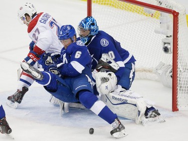 Montreal Canadiens centre Alex Galchenyuk, left, fights for the puck against Tampa Bay Lightning defenceman Anton Stralman, centre, and Lightning goalie Ben Bishop, right, during the second period of game three of their NHL eastern conference semi-final hockey series at Amalie Arena in Tampa on Wednesday, May 6, 2015.
