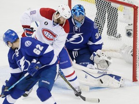 Montreal Canadiens right wing Brandon Prust, centre, attempts a shot against Tampa Bay Lightning goalie Ben Bishop, right, as Tampa Bay Lightning defenceman Andrej Sustr, left, looks on during the second period of game three of their NHL eastern conference semi-final hockey series at Amalie Arena in Tampa on Wednesday, May 6, 2015.