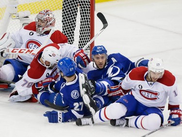 Left to right: Montreal Canadiens goalie Carey Price,  Canadiens defenceman Andrei Markov,  Tampa Bay Lightning left wing Jonathan Drouin,  Lightning right wing Ryan Callahan, and Canadiens centre Torrey Mitchell fall in front of the net during the second period of game four of their NHL eastern conference semi-final hockey series at Amalie Arena in Tampa on Thursday, May 7, 2015.