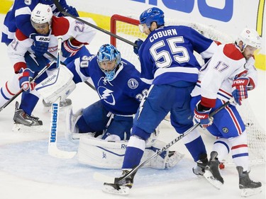 Left to right: Montreal Canadiens right wing Devante Smith-Pelly, Tampa Bay Lightning goalie Ben Bishop, Lightning defenceman Braydon Coburn and Montreal Canadiens centre Torrey Mitchell battle for the puck during the second period of game four of their NHL eastern conference semi-final hockey series at Amalie Arena in Tampa on Thursday, May 7, 2015.