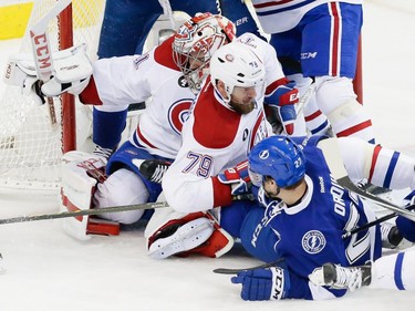 Left to right: Montreal Canadiens goalie Carey Price,  Canadiens defenceman Andrei Markov, and Tampa Bay Lightning left wing Jonathan Drouin fall in front of the net during the second period of game four of their NHL eastern conference semi-final hockey series at Amalie Arena in Tampa on Thursday, May 7, 2015.