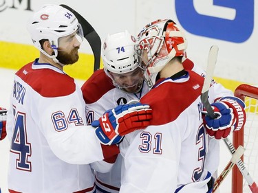 Montreal Canadiens goalie Carey Price, right, is congratulated by teammates Alexei Emelin, centre, and Greg Pateryn, left, winning game four of their NHL eastern conference semi-final hockey series against the Tampa Bay Lightning at Amalie Arena in Tampa on Thursday, May 7, 2015.