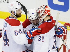 Canadiens goalie Carey Price is congratulated by teammates Greg Pateryn (No. 64) and Alexei Emelin after beating the Lightning 6-4 in Game 4 of Eastern Conference semifinal series on May 7 in Tampa, Fla.