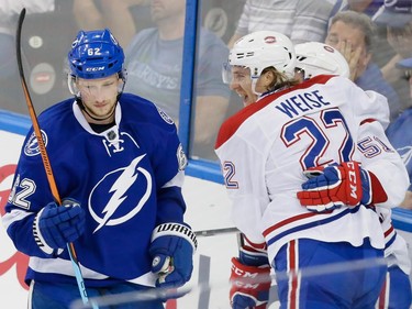 Montreal Canadiens right wing Dale Weise, right, congratulates Montreal Canadiens centre David Desharnais, obscured, for his goal as Tampa Bay Lightning defenceman Andrej Sustr, left, skates past during the second period of game four of their NHL eastern conference semi-final hockey series at Amalie Arena in Tampa on Thursday, May 7, 2015.