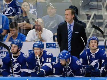 Tampa Bay Lightning head coach Jon Cooper, top, looks on from the bench during the third period of game four of their NHL eastern conference semi-final hockey series at Amalie Arena in Tampa on Thursday, May 7, 2015.