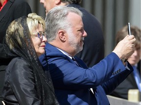 Quebec Prime Minister Philippe Couillard takes a picture with his mobile phone next to his wife, Suzanne Pilote, as they wait for Pope Francis' arrival for his weekly general audience in St. Peter's Square May 27, 2015.