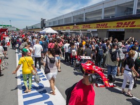 Formula One fans stroll the pit lane area of Circuit Gilles Villeneuve during the 2015 open house at the Île Notre Dame track.