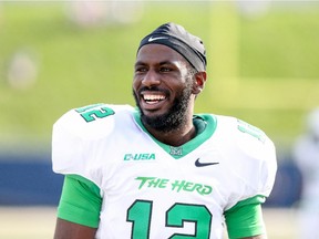 Marshall quarterback Rakeem Cato smiles as he walks the sideline during NCAA game against Akron on Sept. 20, 2014, at InfoCision Stadium in Akron, Ohio.