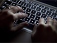 A woman uses her computer keyboard to type while surfing the internet in North Vancouver, B.C., on Wednesday, December, 19, 2012. Digital dissenters known as hacktivists have developed a track record for disruption and attracting attention and are now considered one of the three main groups of attackers online, says security software company Websense. THE CANADIAN PRESS/Jonathan Hayward ORG XMIT: CPT501