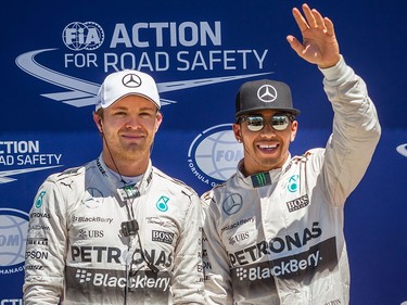 Mercedes driver Lewis Hamilton (right) waves after qualifying with pole position for the F1 Canadian Grand Prix along with teammate Nico Rosberg (left) on outside pole.